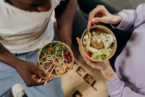 two women eating pasta salad